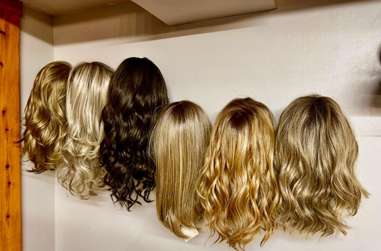 A collection of wigs on display showing several color and style options